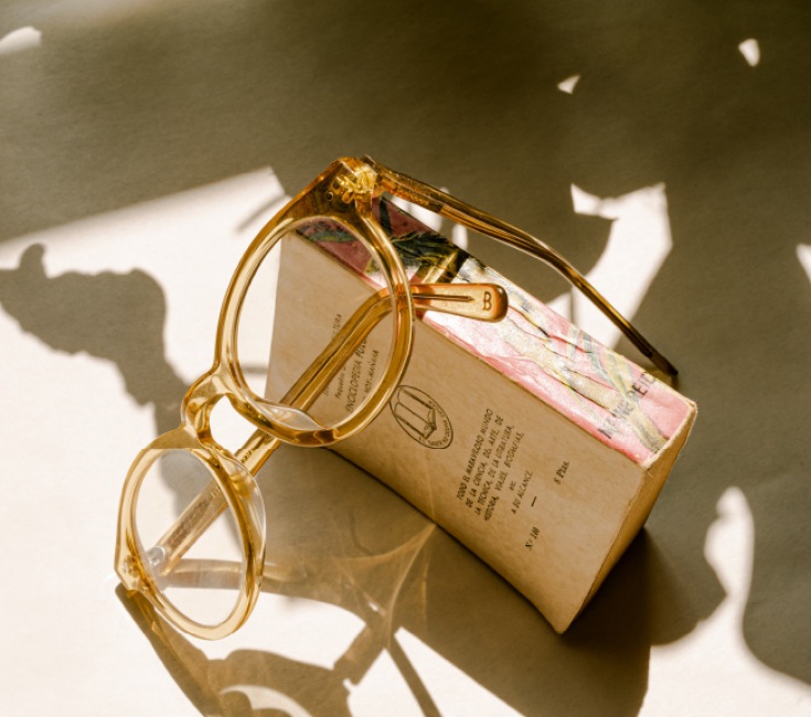 lifestyle image of a pair of reading glasses in a warm-lit setting